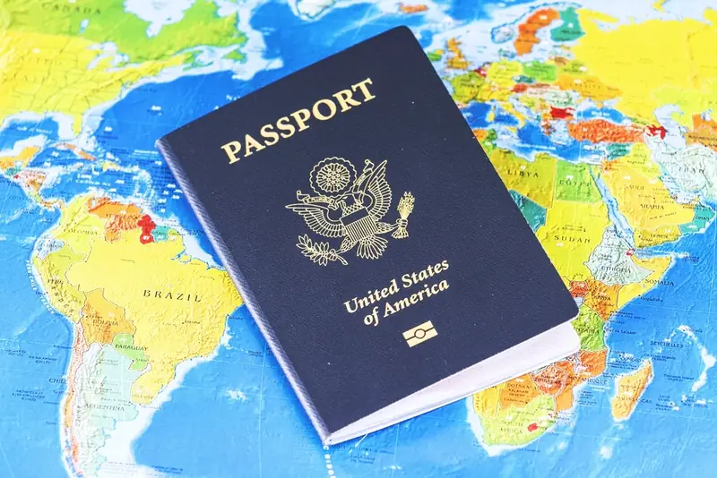United States passport lying on a colorful world map