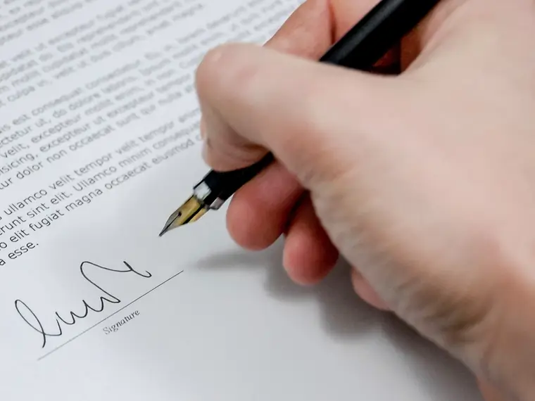 Hand signing a document with a fountain pen