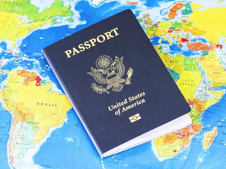United States passport lying on a colorful world map